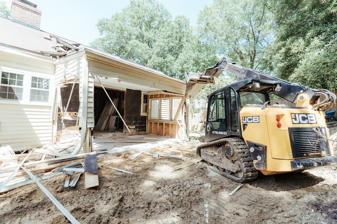 a-bulldozer-is-parked-in-front-of-a-house-u8ushg1pqny